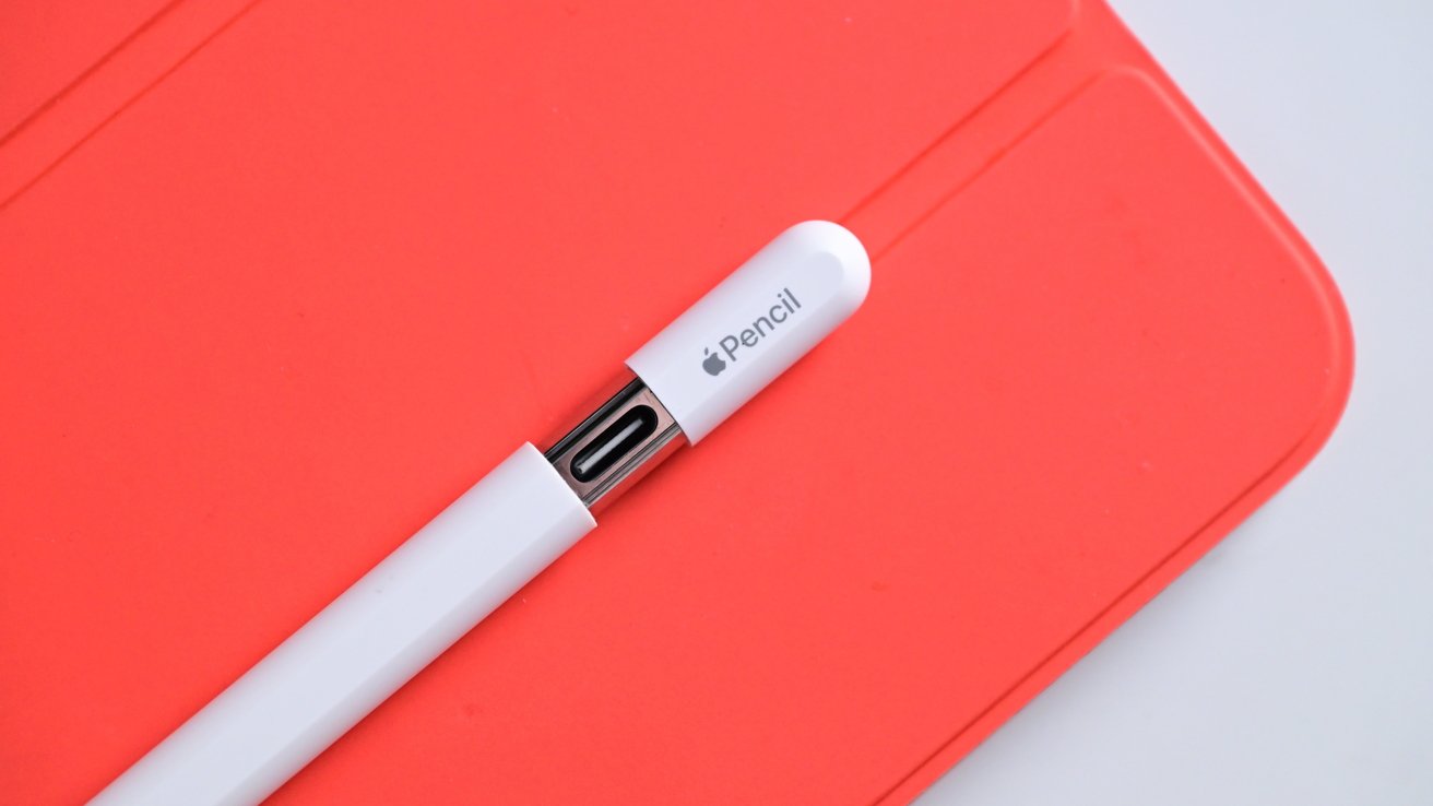 Apple Pencil с USB-C находится на оранжевой магнитной крышке iPad