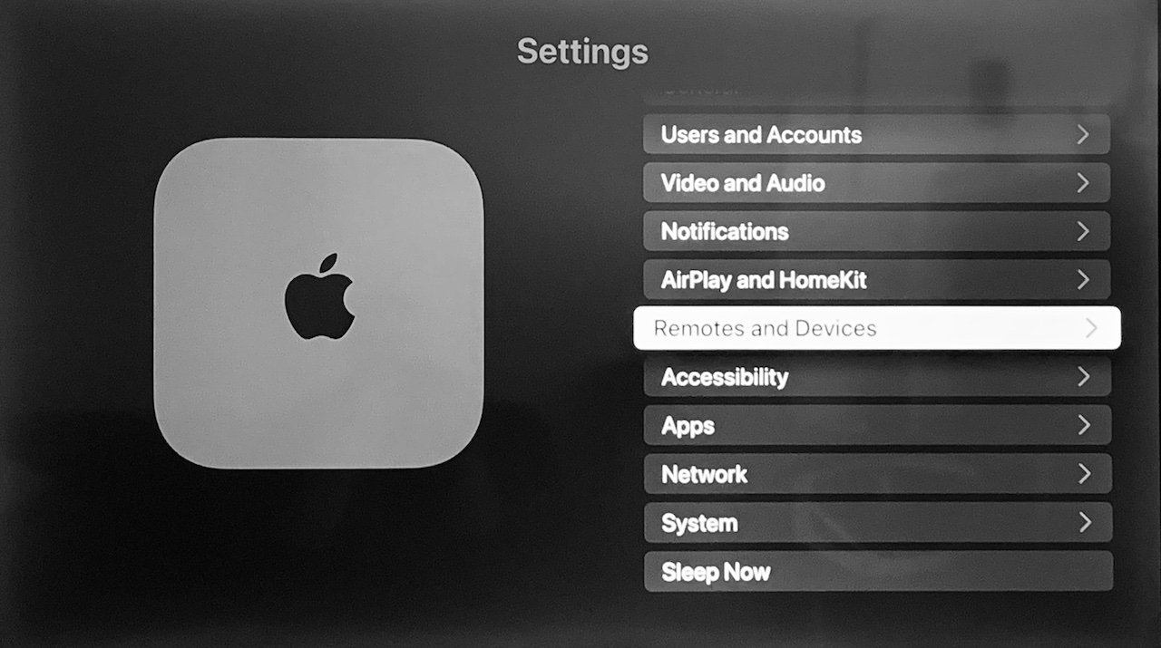 Черно-белая фотография интерфейса Apple TV с различными пунктами меню, такими как «Настройки», «Специальные возможности» и «Сеть».