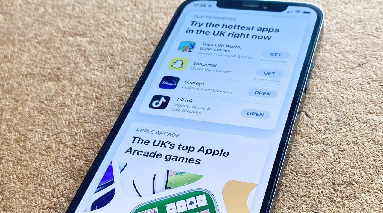Изображение iPhone на ковре с открытой британской версией App Store.