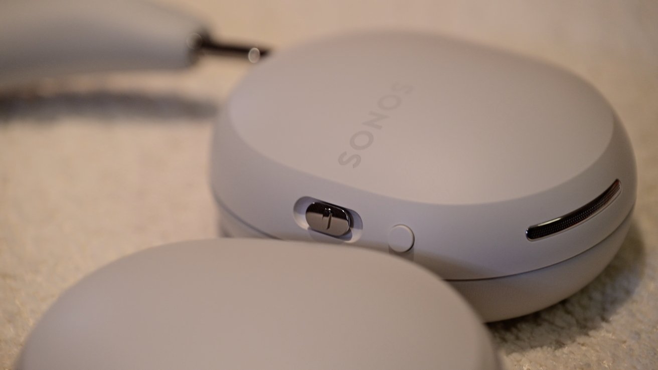 Тумблер из нержавеющей стали на наушниках Sonos Ace, который можно перемещать вверх и вниз.