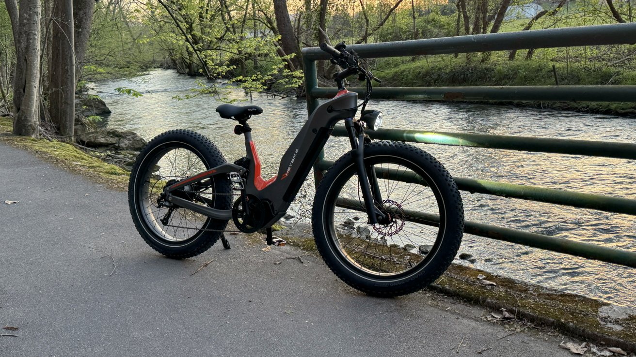 Heybike Hero припарковался на перилах у ручья.  Его фара светит на рельс.