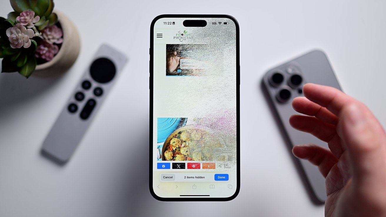 iPhone на белом столе, изображение распадается на мелкие части и исчезает за пределами экрана.