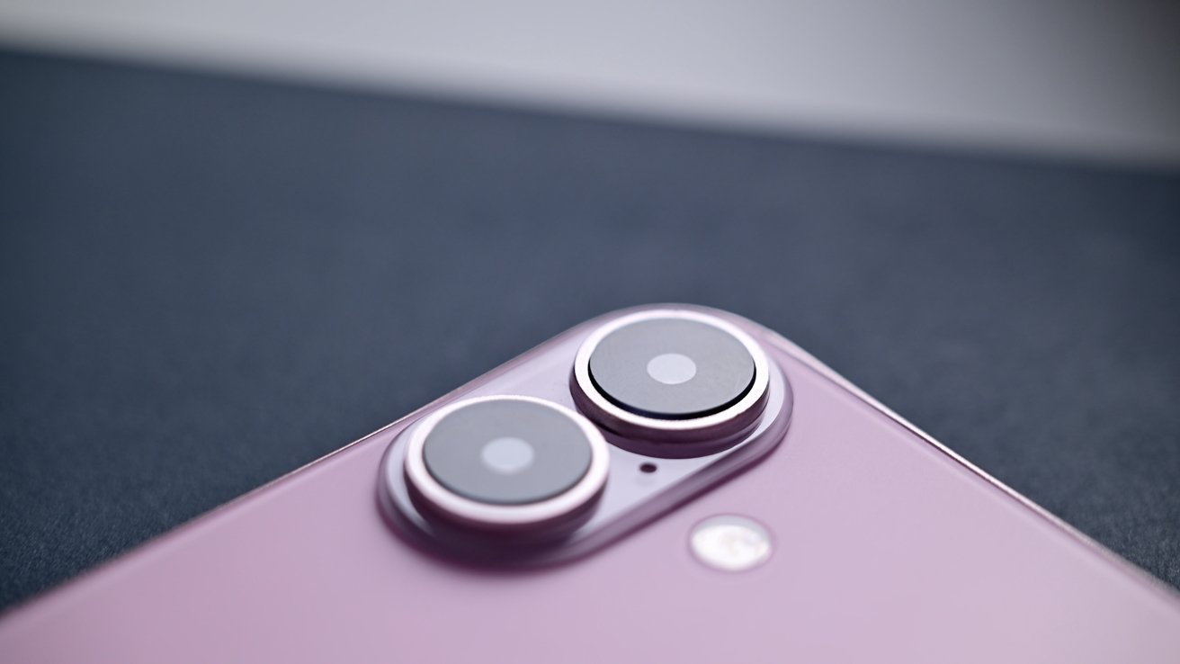 Крупным планом показаны вертикально расположенные камеры на розовом макете iPhone 16