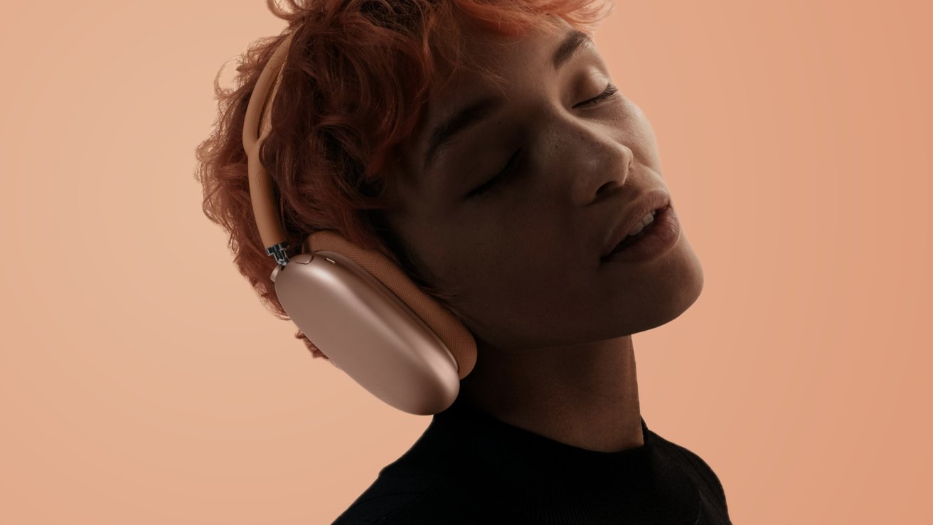 Человек с рыжими волосами и оранжевыми AirPods Max на оранжевом фоне