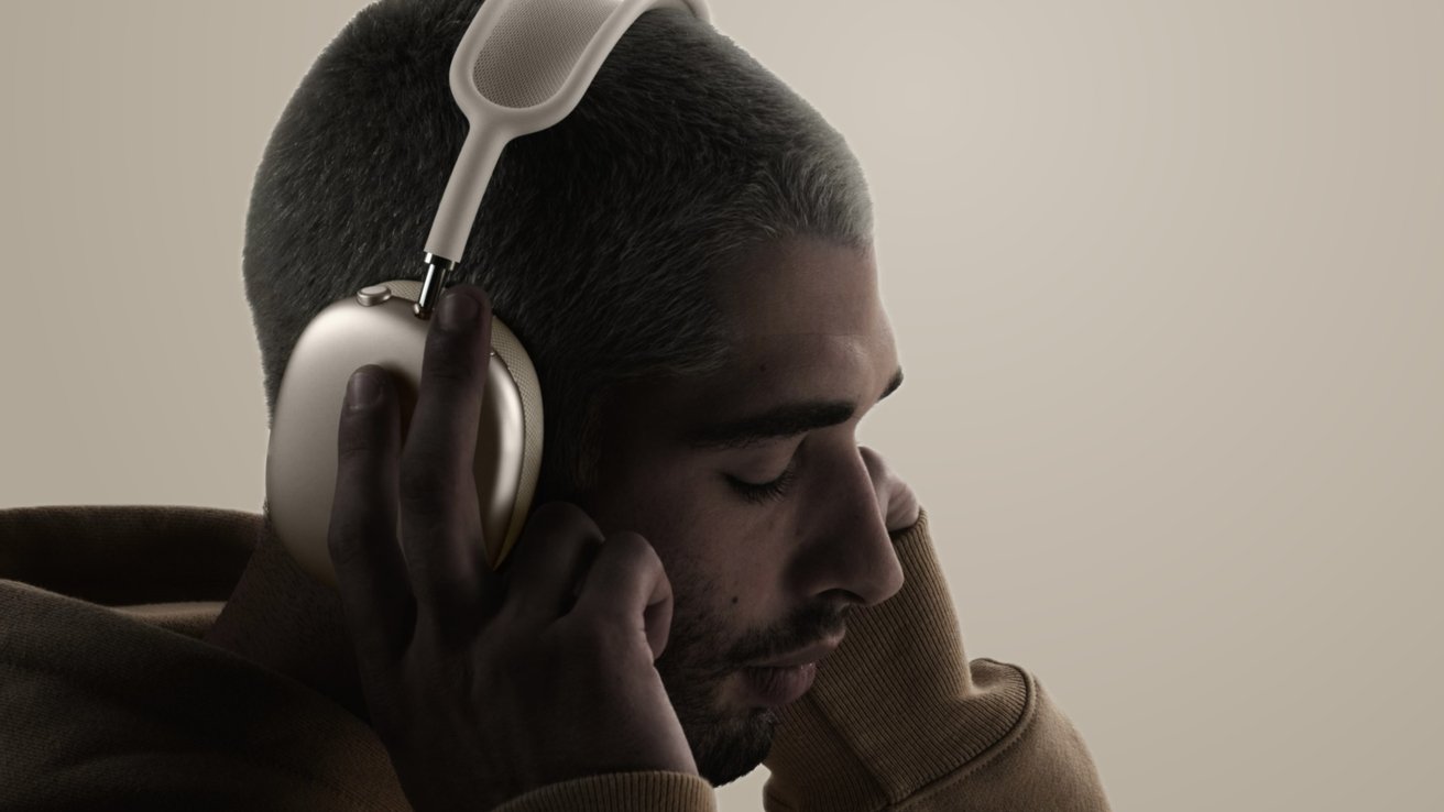 Человек, держащий наушники Starlight AirPods Max в руках