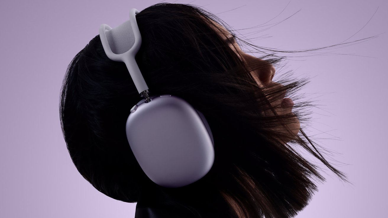 Человек с темными волосами в фиолетовых наушниках AirPods Max
