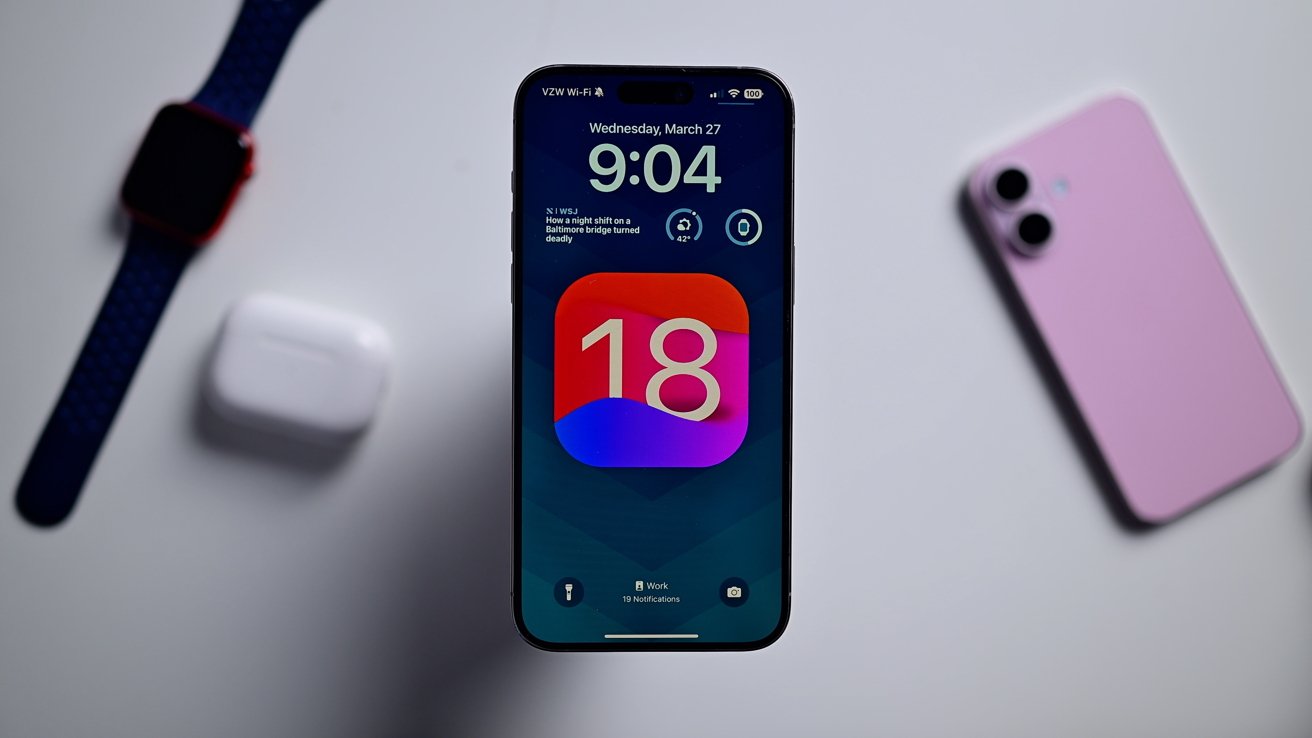 iPhone на белом столе с экраном обновления iOS 18