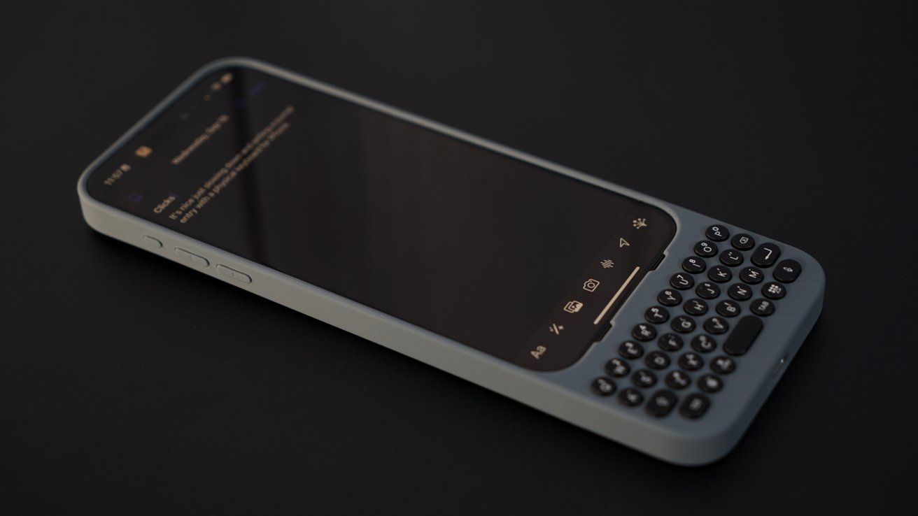 Смартфон с физической QWERTY-клавиатурой, расположенный на темной поверхности, отображает текстовое сообщение на экране.