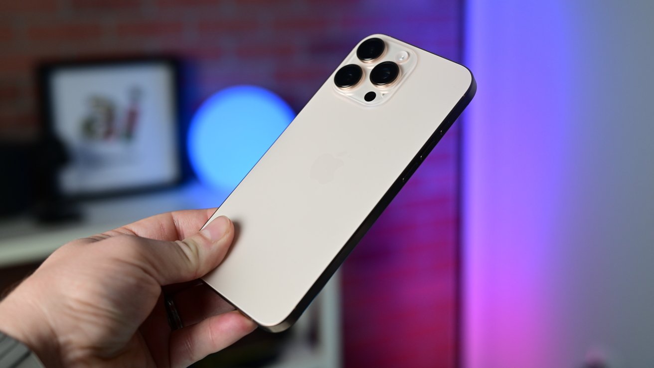Титановый iPhone 16 Pro Max в пустыне, на заднем плане, при ярком студийном освещении