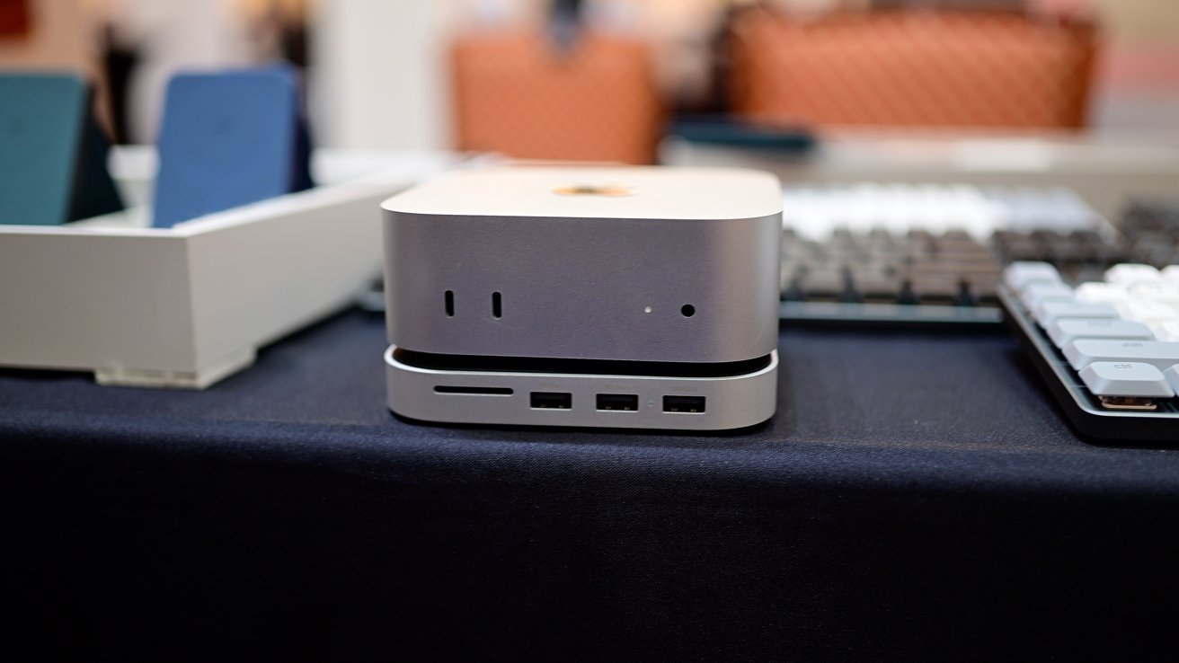 Новый Mac mini на металлическом основании меньшего размера с несколькими портами на передней панели.