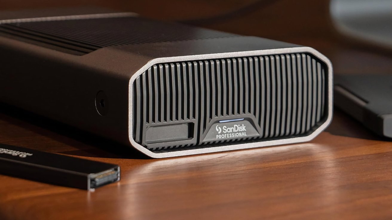 Черный внешний жесткий диск с профессиональным брендом Sandisk, отдыхающий на деревянной поверхности, в котором есть рисунок на передней панели.