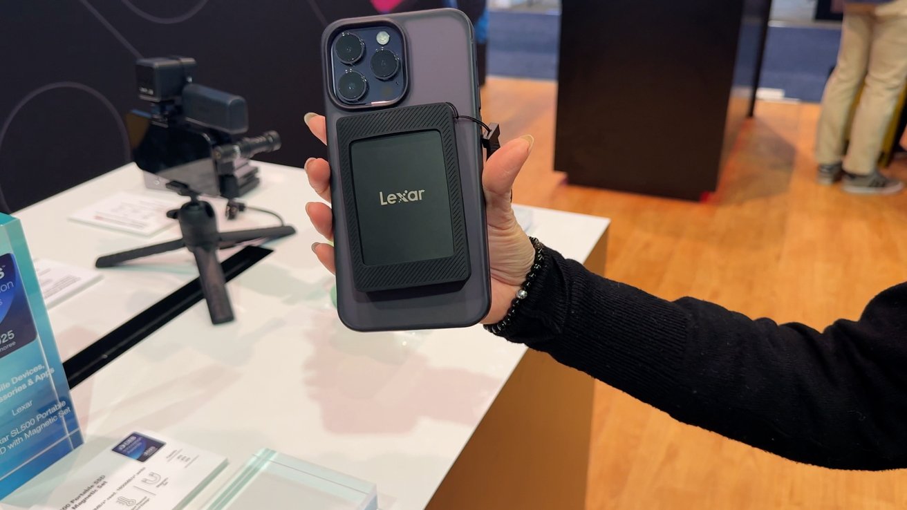 Рука держит смартфон с прикрепленным аксессуаром Lexar в магазине техники.
